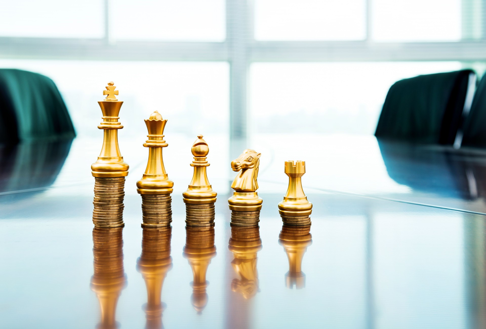Chess pieces standing on the stacked coins
